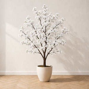Cerisier en fleurs artificiel 210 cm à fleurs blanches, dans un pot en céramique crème, sur un parquet en chêne à bâtons rompus