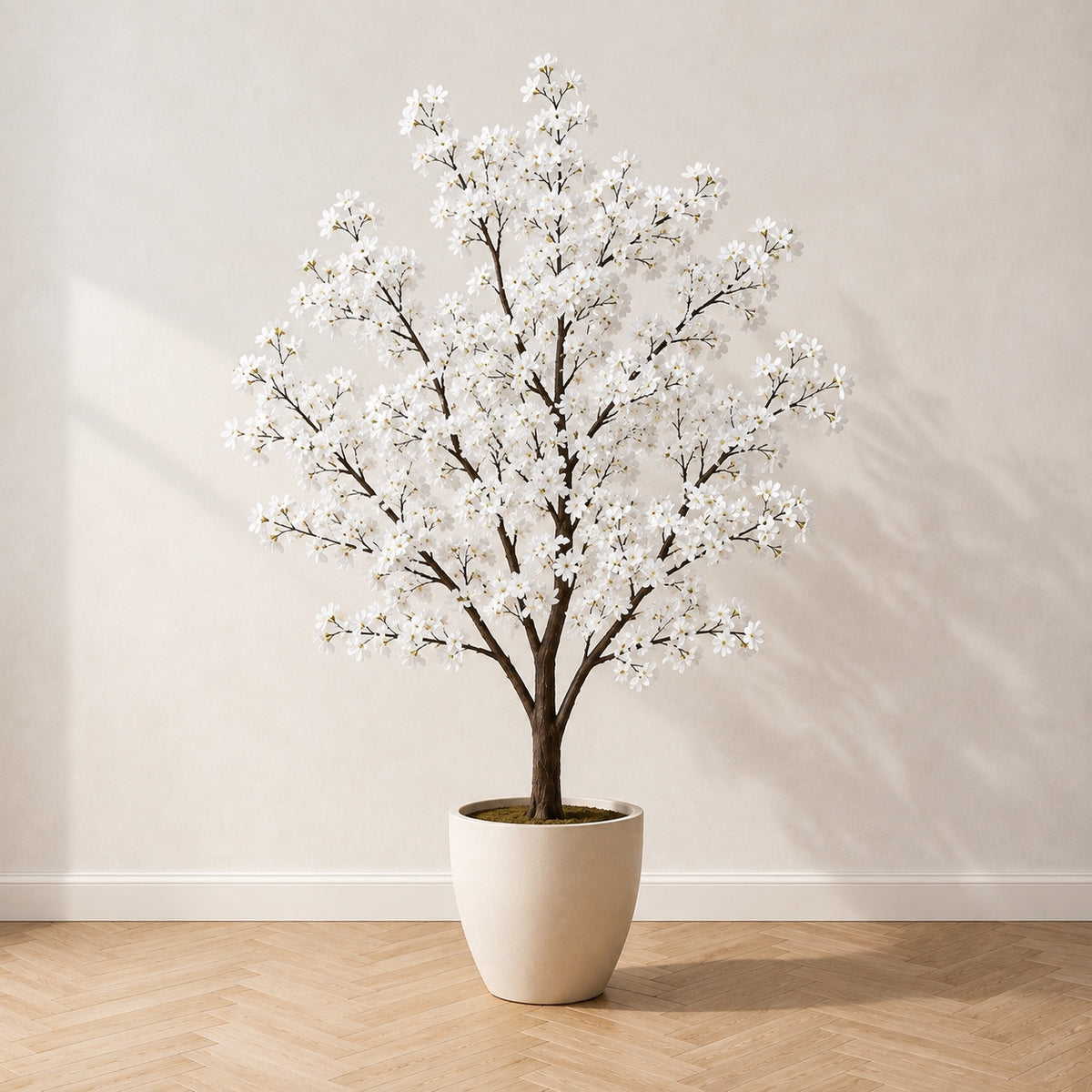 Cerisier en fleurs artificiel 210 cm à fleurs blanches, dans un pot en céramique crème, sur un parquet en chêne à bâtons rompus