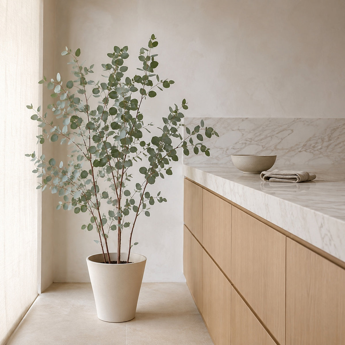 Eucalyptus artificiel 130 cm dans une cuisine ouverte, plan de travail en marbre veiné