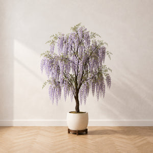 Glycine artificielle 180 cm à grappes mauves retombantes, dans un pot crème posé sur un pied en bois, sur un parquet en chêne à bâtons rompus
